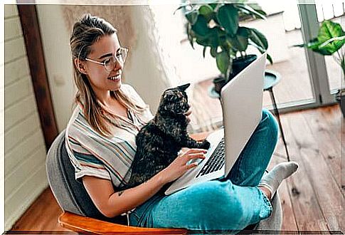 Woman at the computer with her cat.