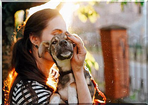 Adopt a dog: woman cuddles her dog.